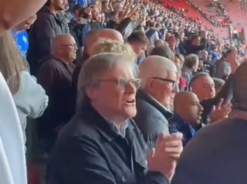 a group of people are sitting in a stadium watching a game .