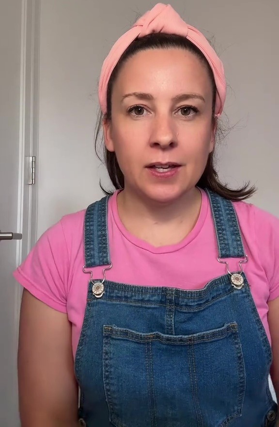 a woman wearing overalls and a pink headband