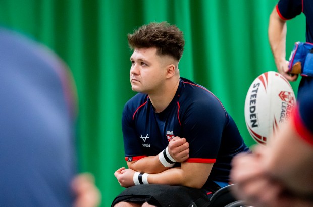 a man sits in front of a rugby ball that says steelden on it