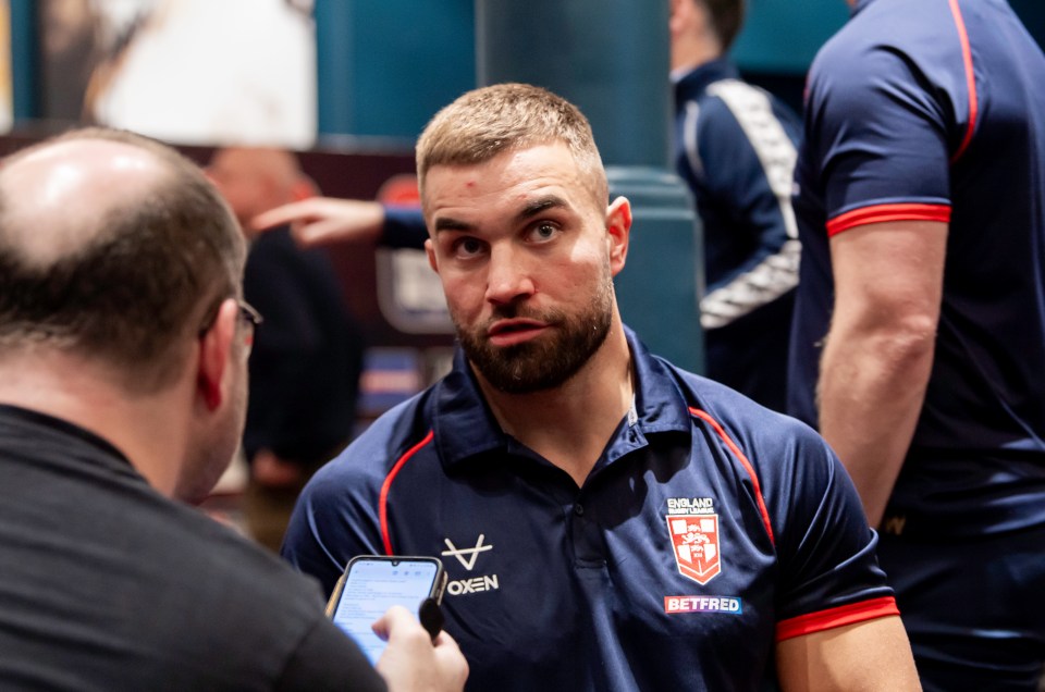 a man wearing an oxen shirt is talking to another man