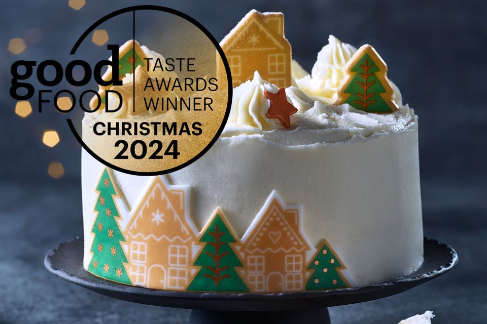 a christmas cake with gingerbread houses and trees on it