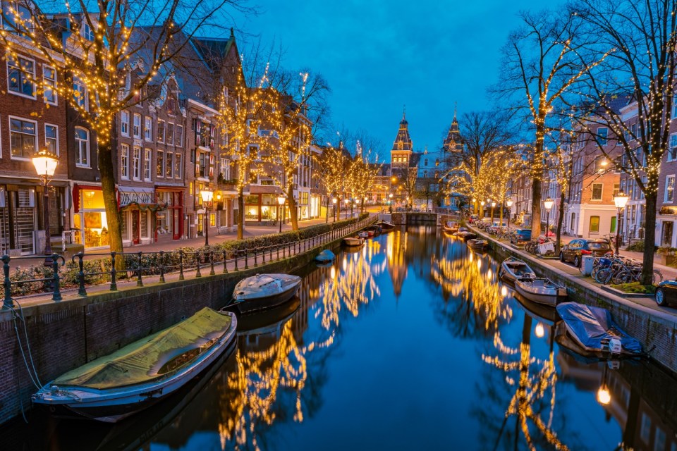 a row of boats are lined up along a canal in amsterdam