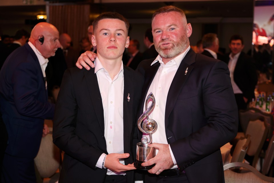 Kai poses with his dad after he collected the prize