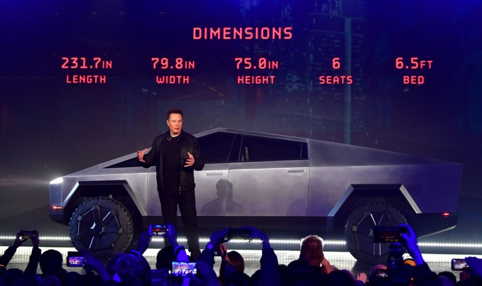 Tesla co-founder and CEO Elon Musk discusses vehicle dimensions in front of the newly unveiled all-electric battery-powered Tesla Cybertruck at Tesla Design Center in Hawthorne, California on November 21, 2019. (Photo by Frederic J. BROWN / AFP) (Photo by FREDERIC J. BROWN/AFP via Getty Images)