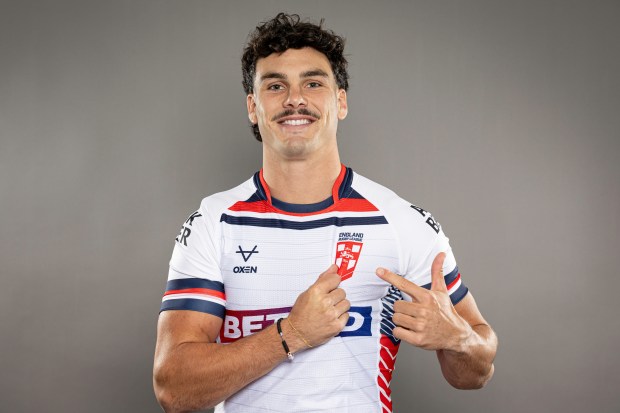 a man wearing a england rugby jersey is giving a thumbs up