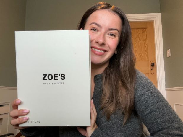 a woman holds up a zoe 's advent calendar