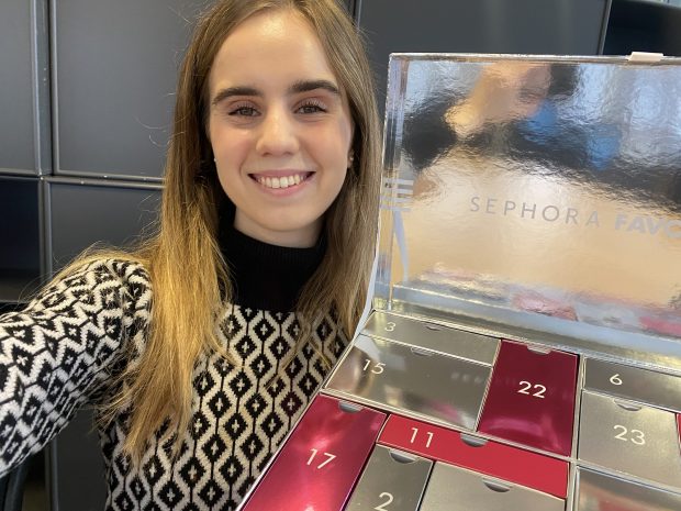 a woman holds up a sephora favorites advent calendar