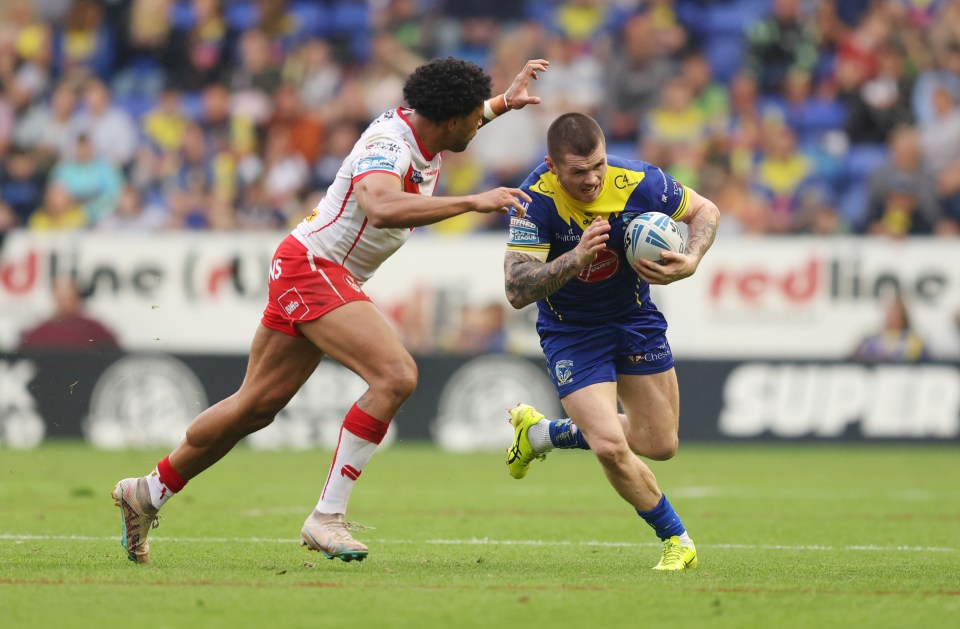 two rugby players on a field with one wearing a jersey that says super