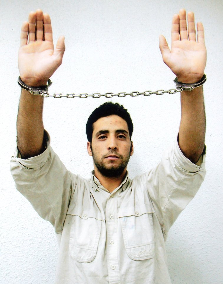 Aziz Tsalha, a Palestinian suspect in a brutal murder of two Israelis, is seen as he holds his cuffed hands in front of him in this posed undated photo released Monday June 25, 2001 by Israel's Shin Bet intelligence agency. Tsalha's pose in the picture is the same as that of a Palestinian who held his hands high, covered with blood, as he leaned out the window of a Palestinian police station in the West Bank town of Ramallah, where two Israeli soldiers were beaten and mutilated October 12 2000. (AP Photo/HO/Courtesy of Yediot Ahronot newspaper) ISRAEL OUT COMMERCIAL ONLINE OUT