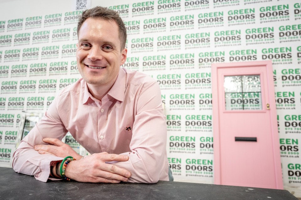 a man stands in front of a wall that says green green green doors