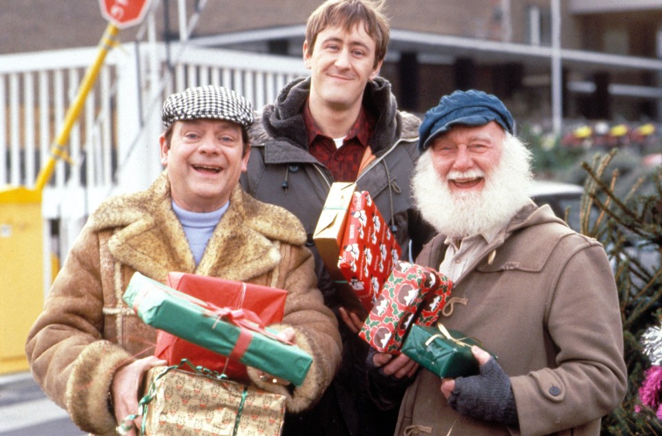 three men are holding christmas presents and smiling for the camera