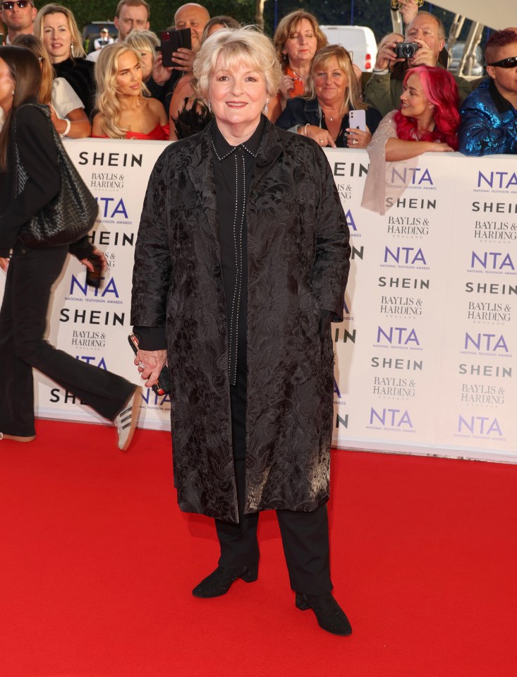 a woman stands on a red carpet in front of a wall that says shein