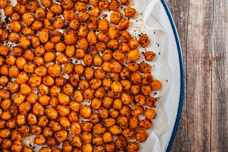 a plate of chickpeas with a blue rim on a wooden table