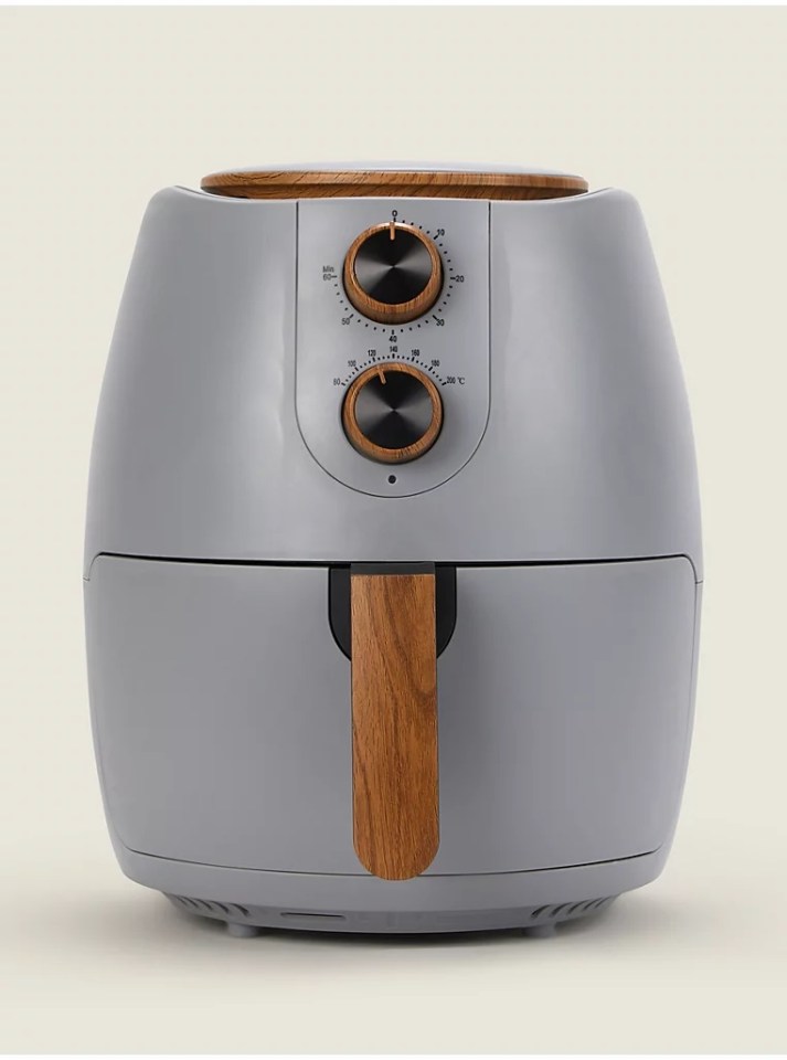 a grey air fryer with a wooden handle