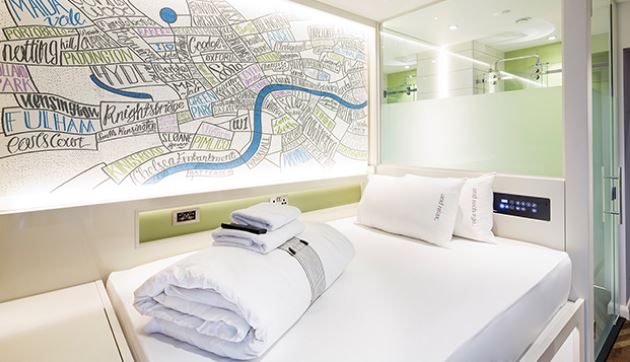 a hotel room with a bed and a map on the wall .