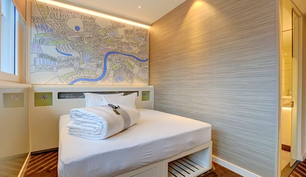 a hotel room with a bed and a map on the wall