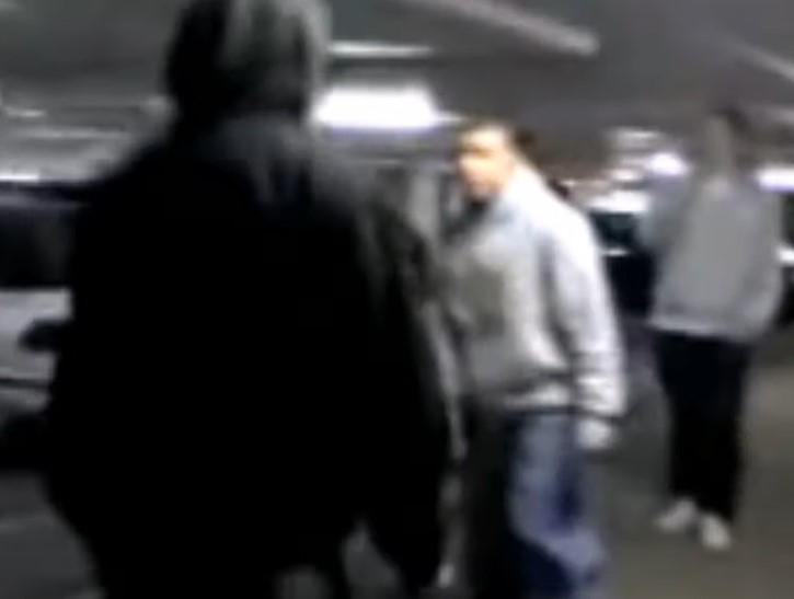 a blurry picture of a group of people standing in a parking garage .