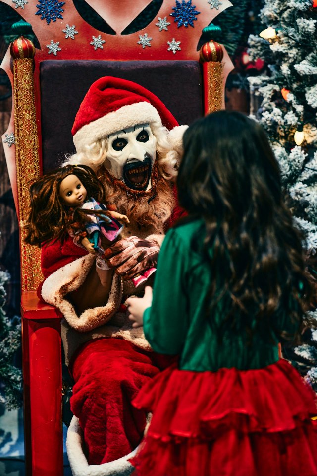 a little girl is playing with a creepy santa claus doll