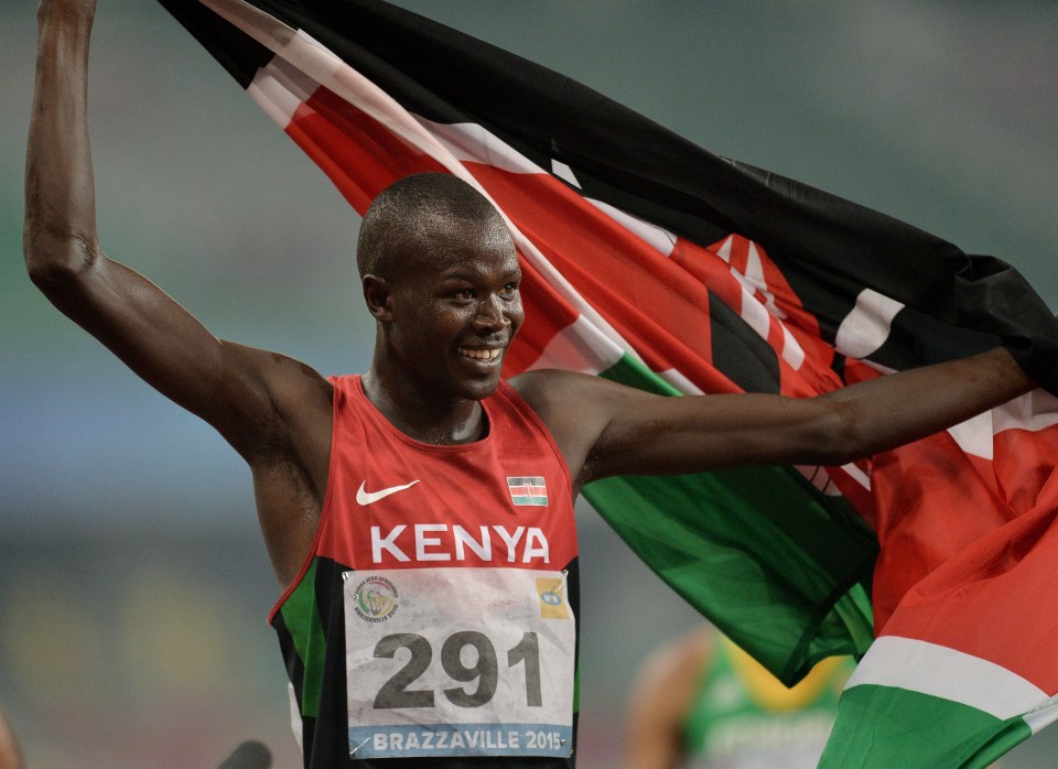 a man in a kenya jersey holds up a flag