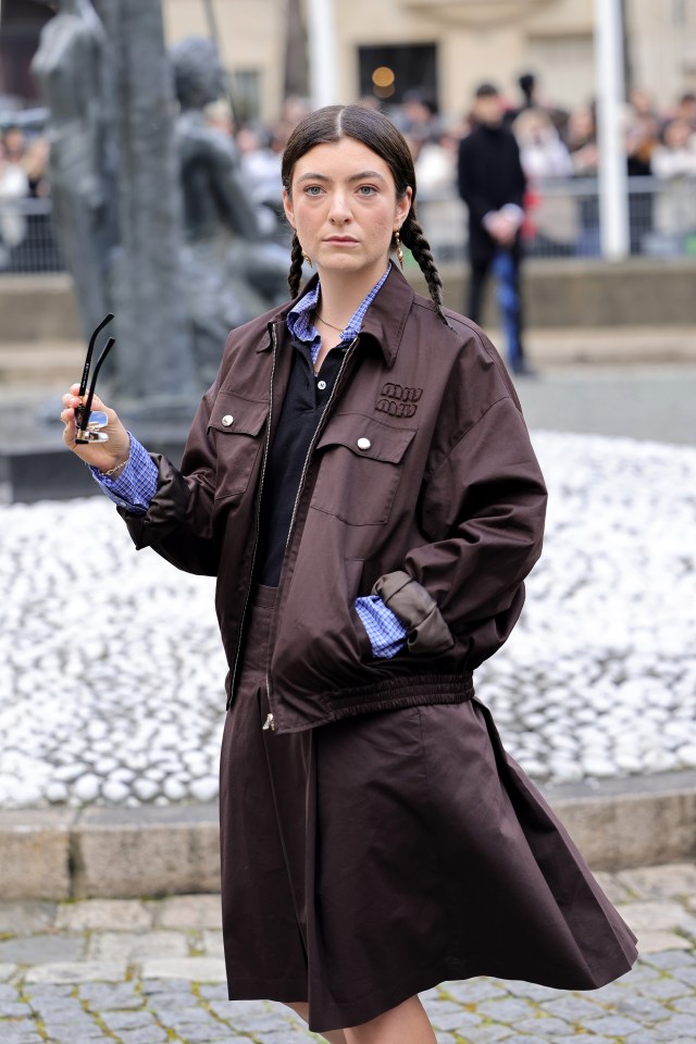 a woman wearing a brown jacket with the word army on it