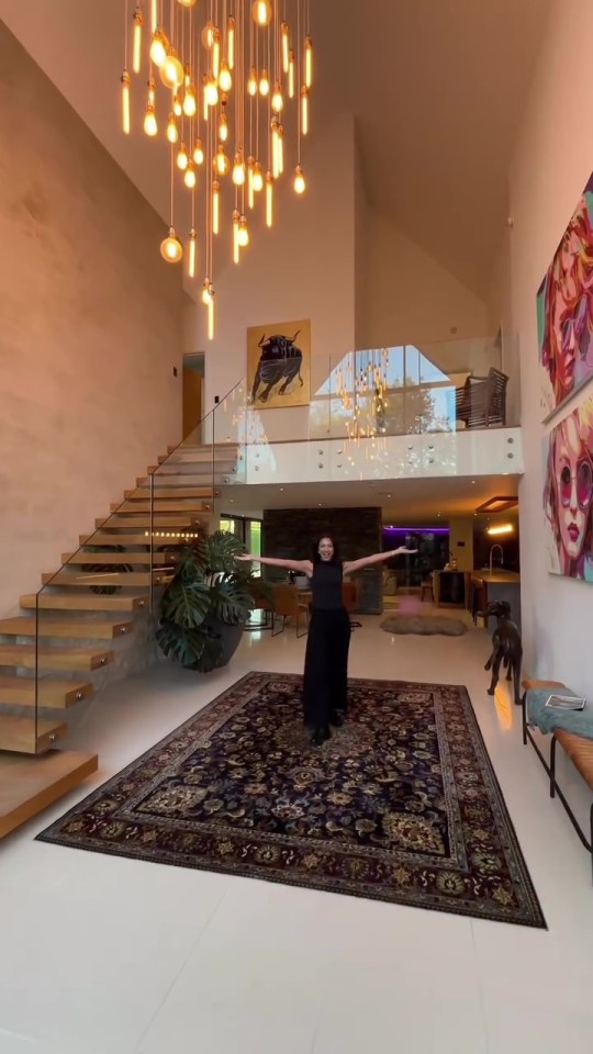 a woman in a black dress is standing in the middle of a large room