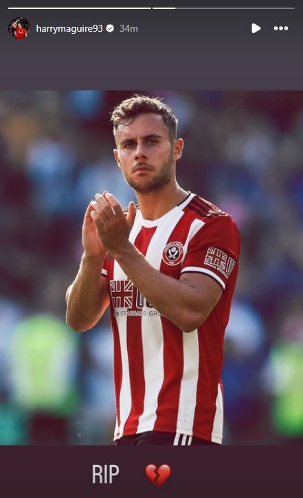 a man in a red and white striped shirt applauds the crowd