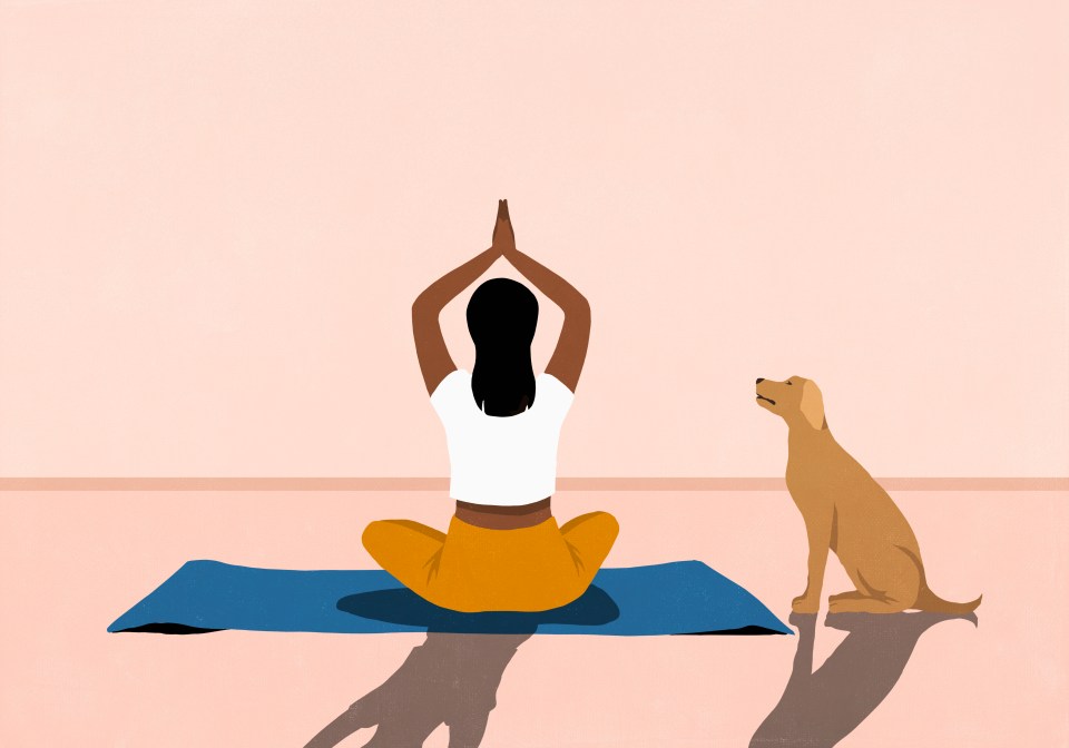 a woman sits on a yoga mat next to a dog