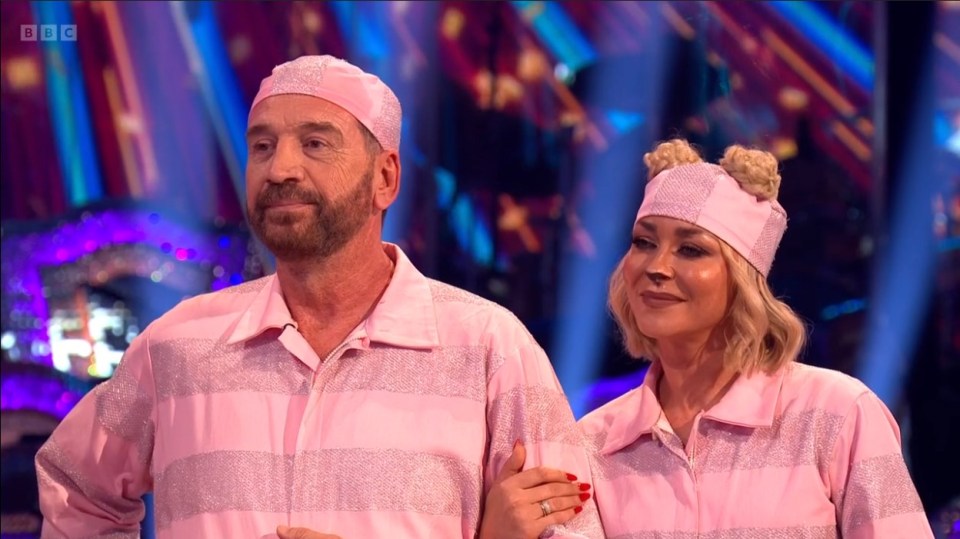 a man and a woman are standing next to each other on a stage with the bbc logo in the background