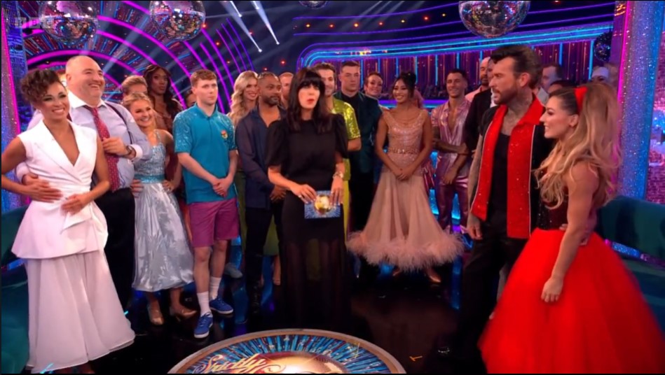 a group of people are posing for a picture and one of them is wearing a red dress