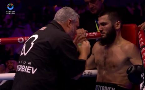 a man is talking to a boxer in a boxing ring .