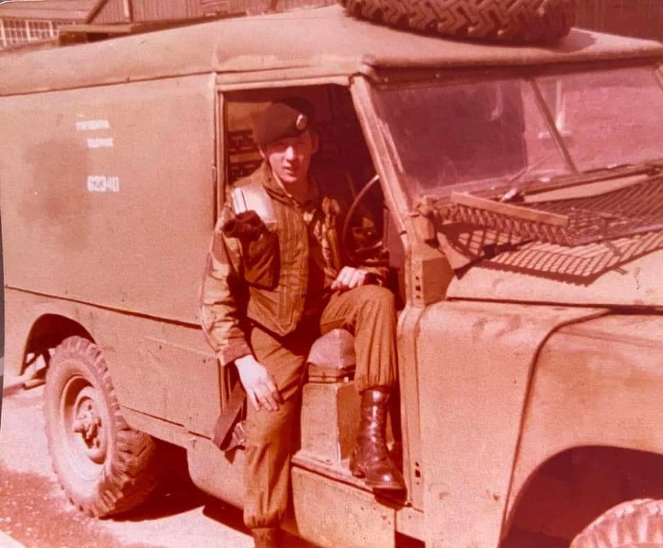 a man sits in the doorway of a military vehicle with the number 622411 on the side