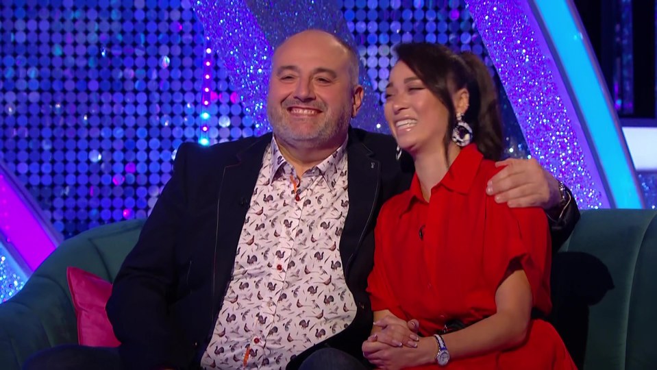 a man and a woman are sitting on a couch and smiling