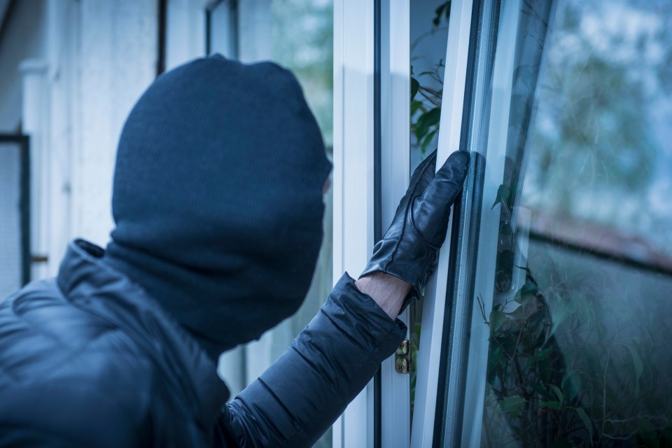 a man in a mask is trying to open a window