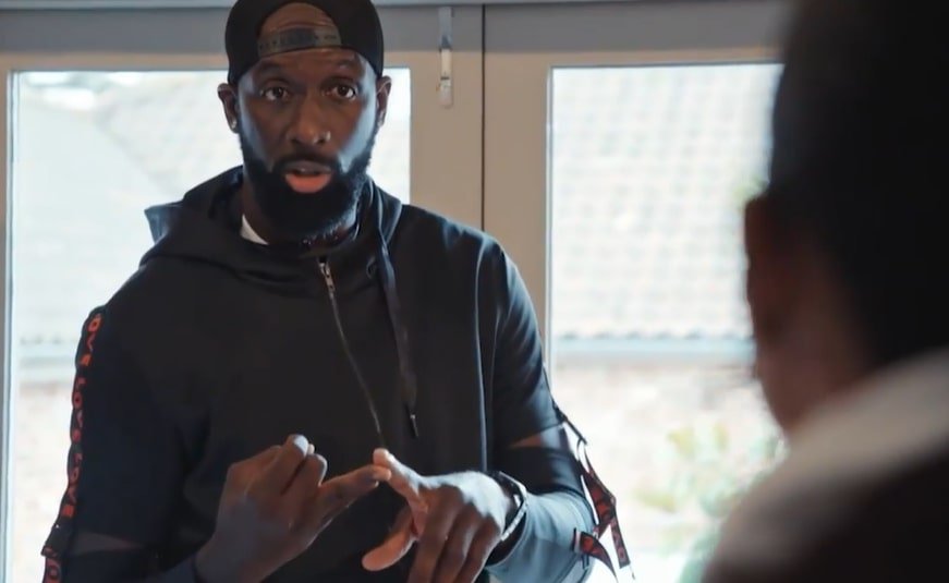 a man with a beard wearing a hat that says ' reebok ' on it