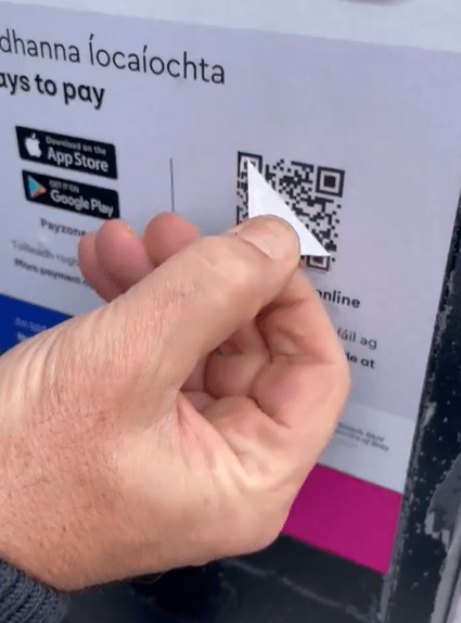 a person is holding a piece of paper with a qr code on it