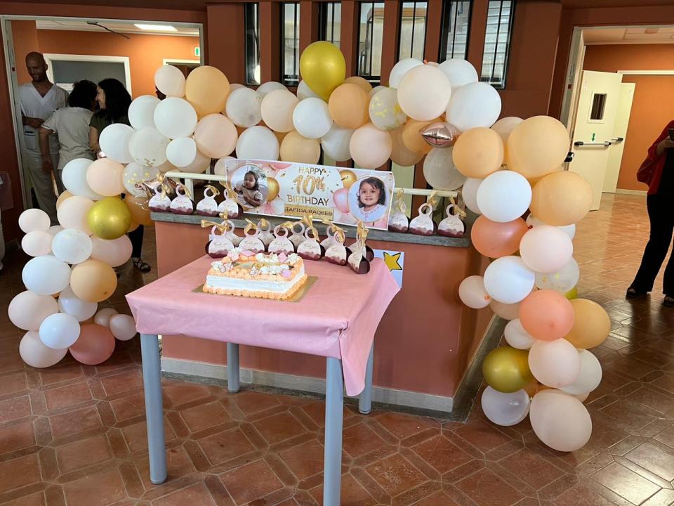 Pictures from the party show a cake with pictures of Tafida on top and peach balloons