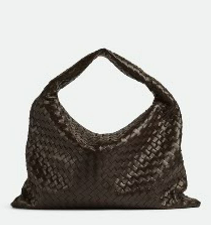 a brown woven bag with a handle on a white background .