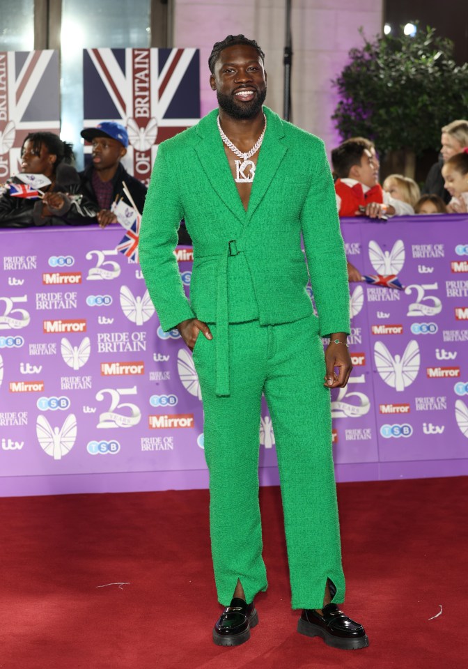 a man in a green suit is on the red carpet