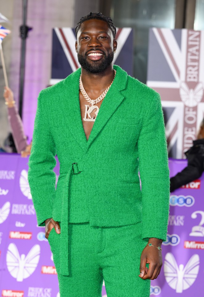 a man in a green suit with the letter k on his chest