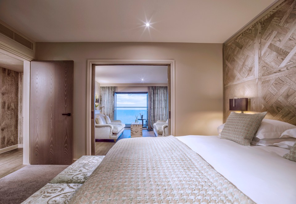 a hotel room with a large bed and a view of the ocean