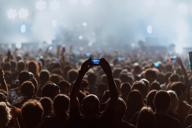 a man is taking a picture of a crowd at a concert