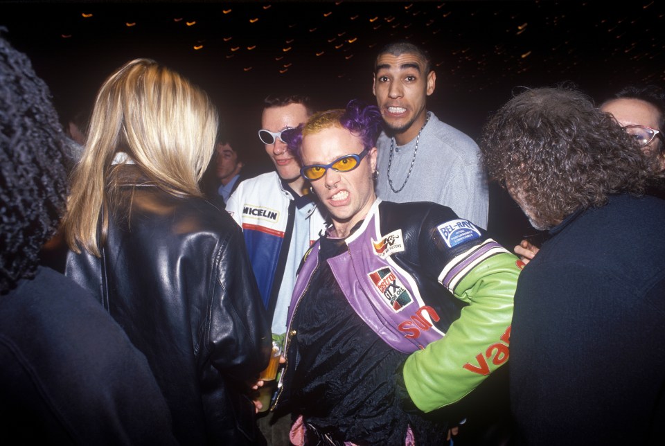 a man with purple hair wears a michelin jacket