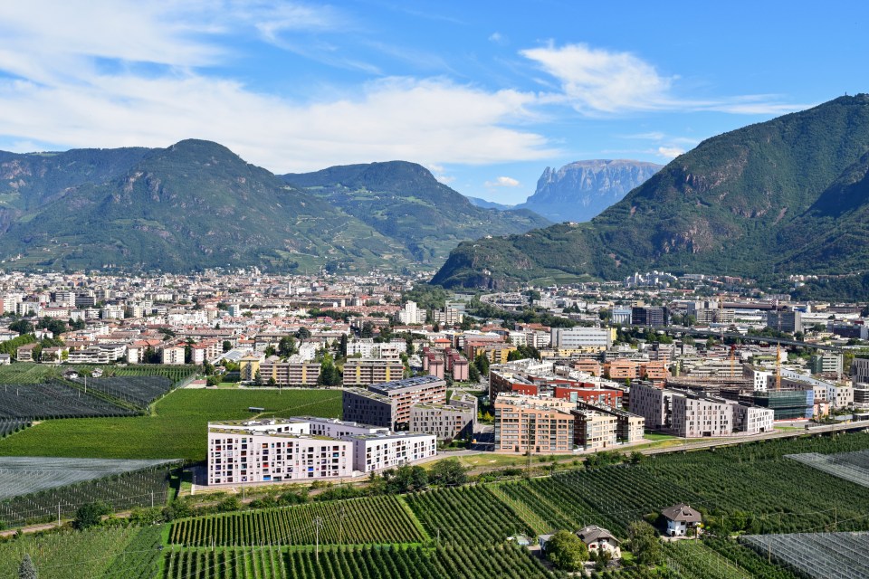 an aerial view of a city with mountains in the background