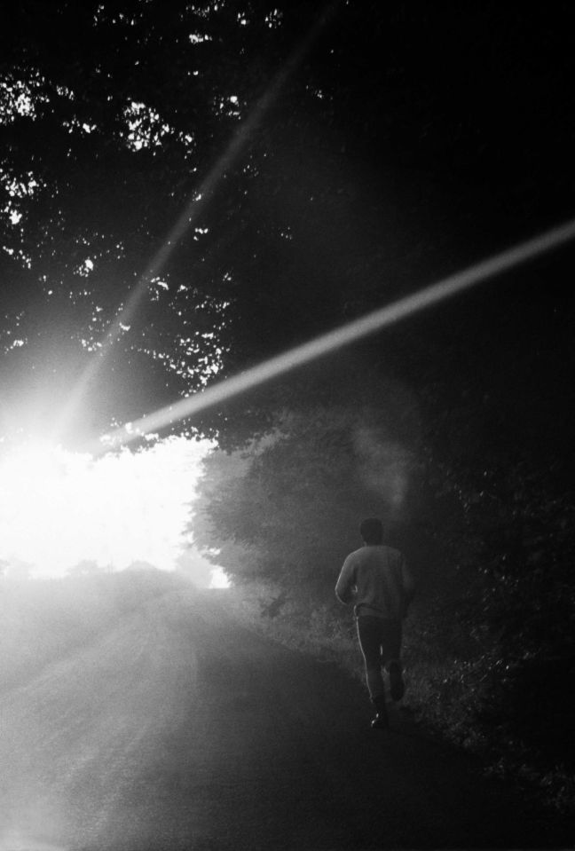 a black and white photo of a person running in the dark