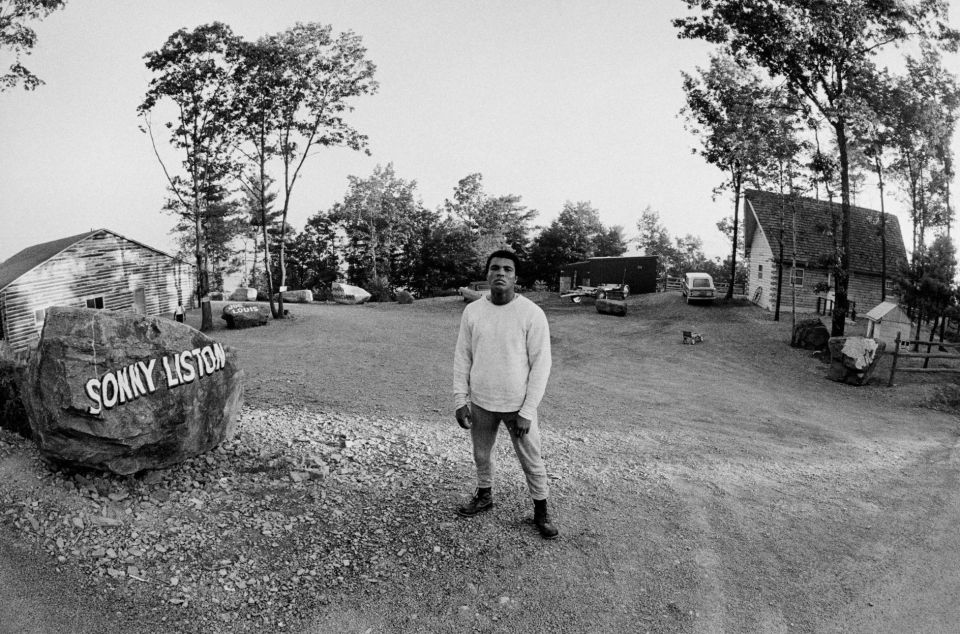 a man stands in front of a rock that says sonny liston