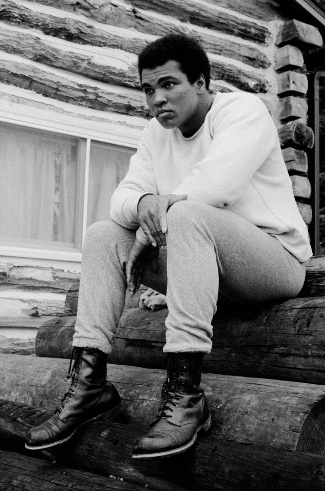 a black and white photo of a man sitting on a log