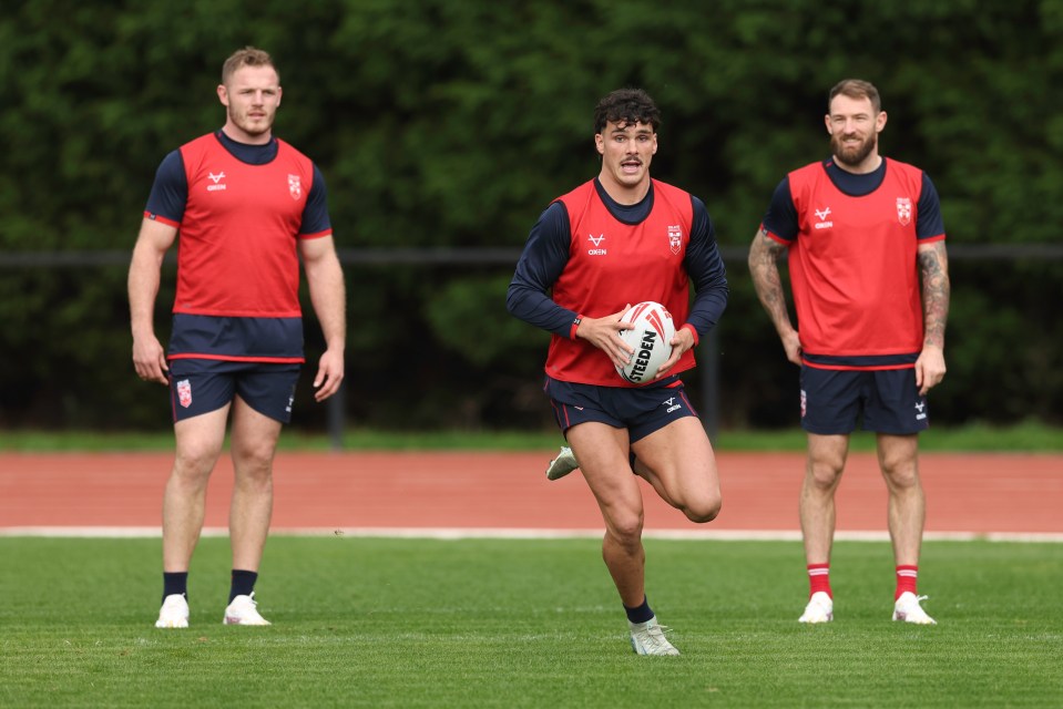 a man holding a rugby ball with the word steeden on it