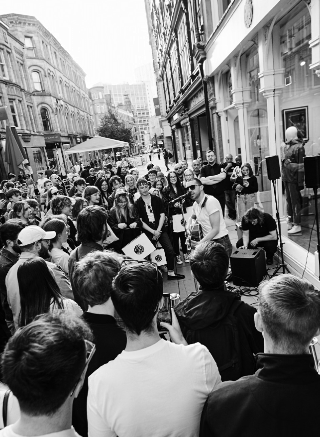 a man playing a guitar in front of a crowd of people