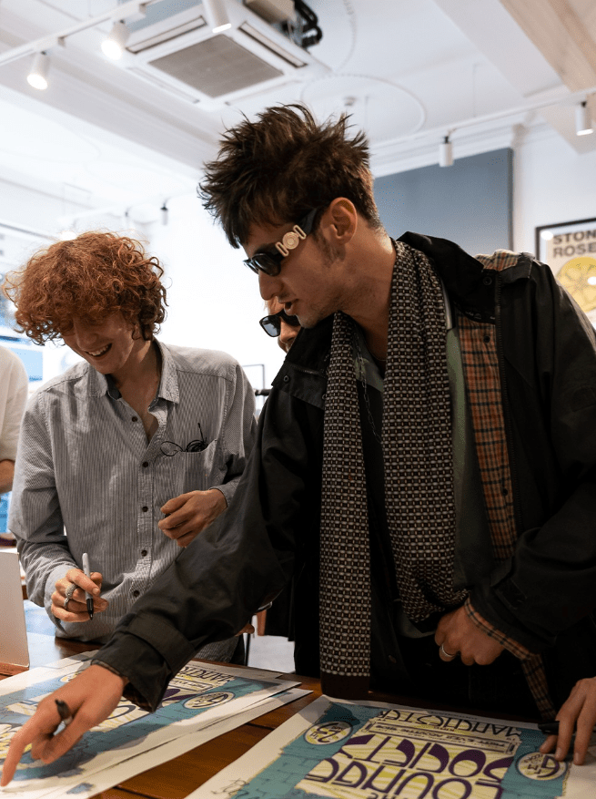 two men are looking at a poster that says taboo sound