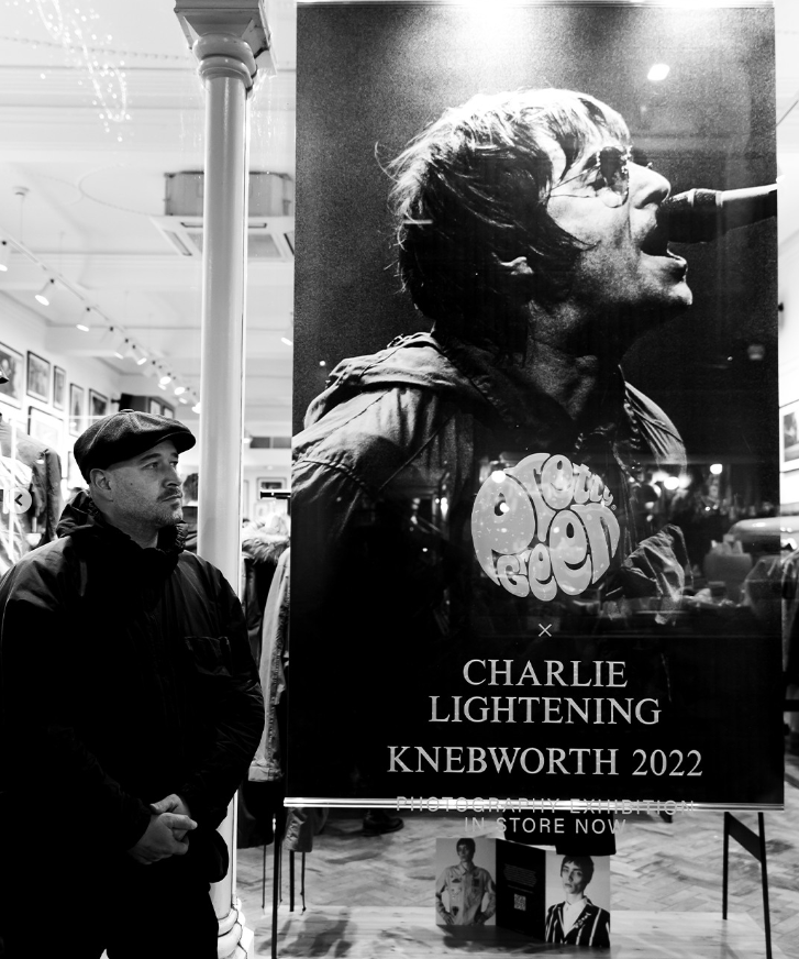 a man stands in front of a charlie lightening poster